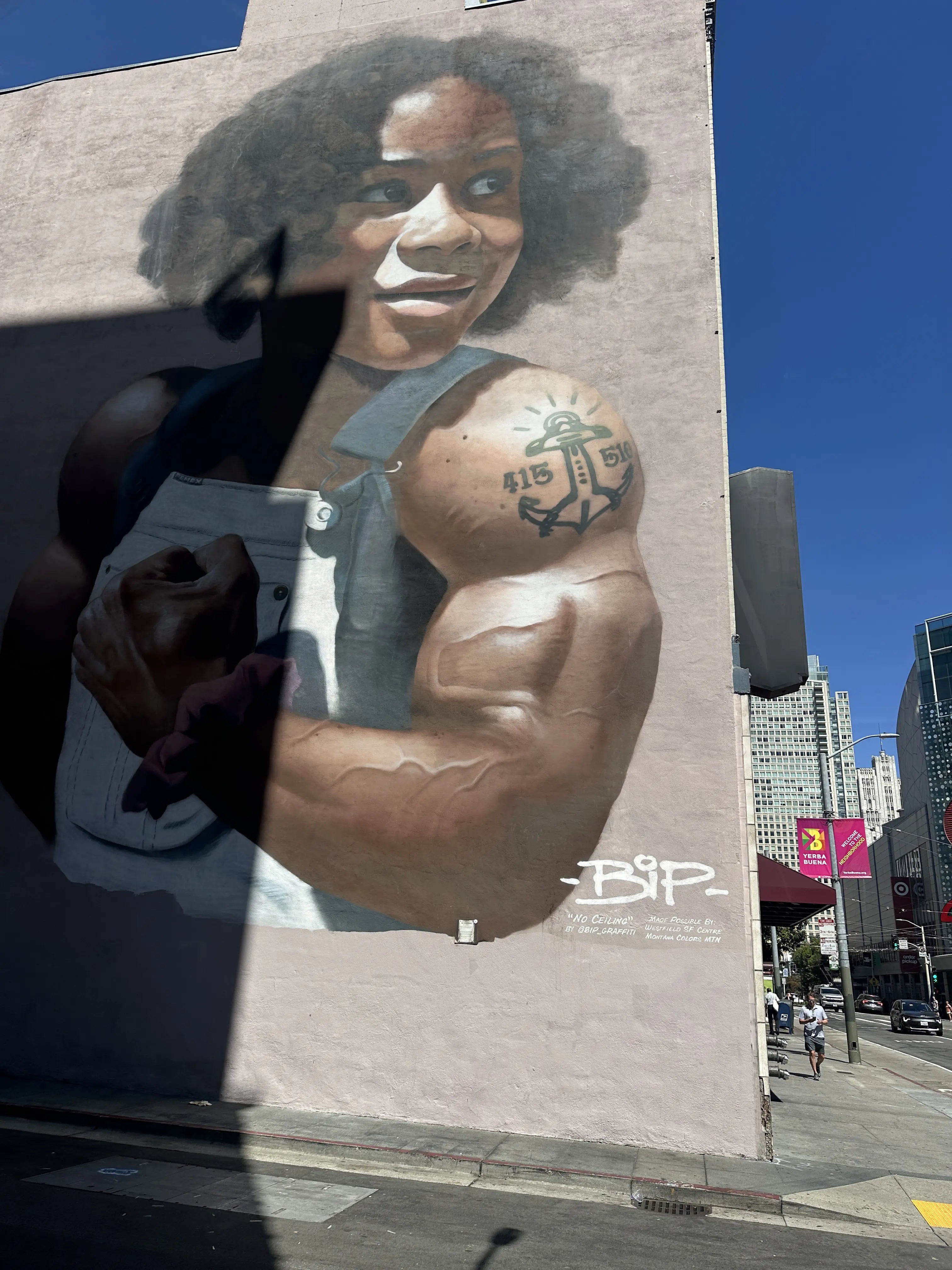 Students in San Francisco’s Mission District stopping at a Balmy Alley mural; one checks a timed question in the Street Art Game app while classmates point out details.