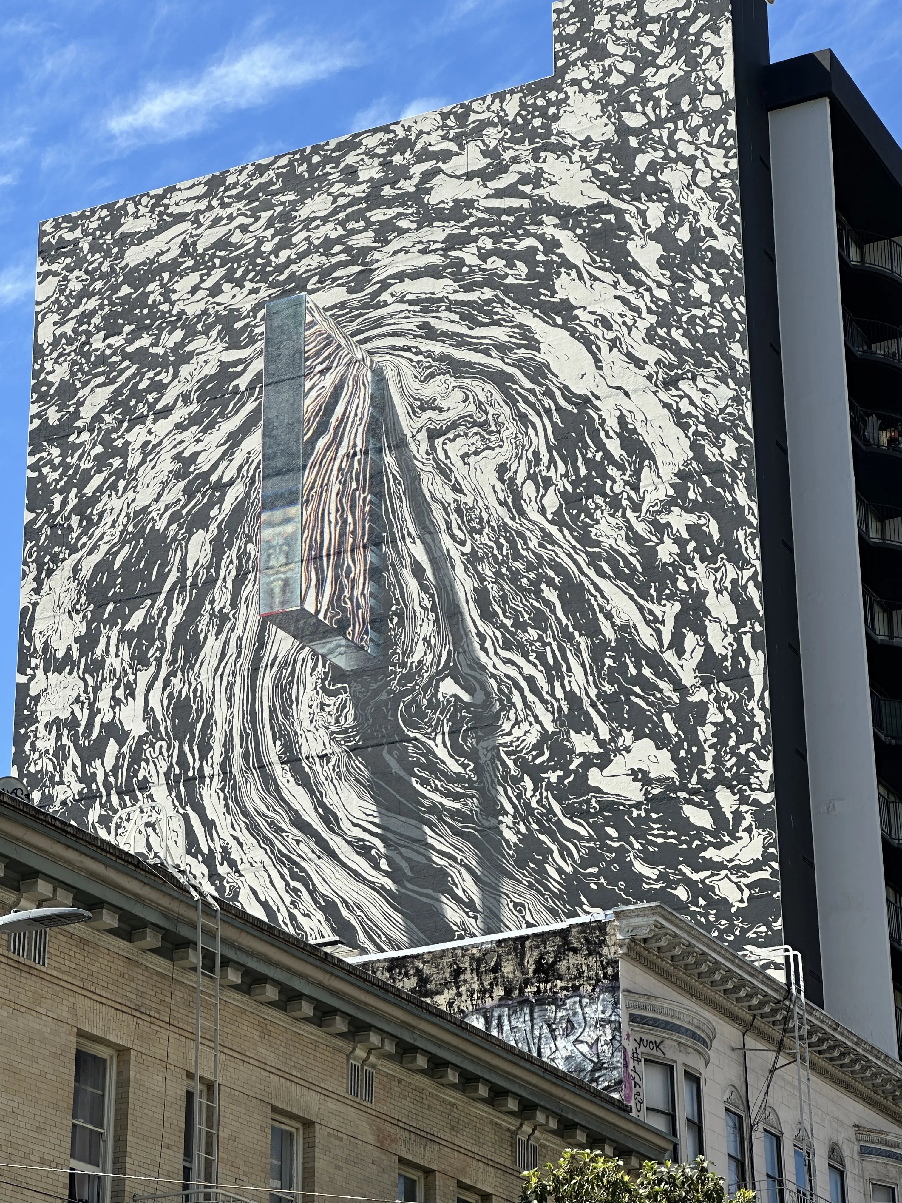 Diverse team at the entrance to Clarion Alley in the Mission District, looking up at a newly painted collaborative mural while using the Street Art Game app.