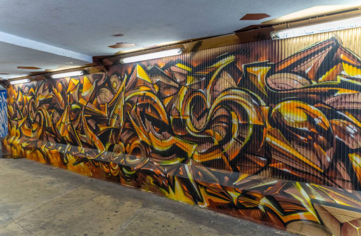 Team selfie by a bold wall at LX Factory during an Interactive Street Art Tour Lisbon