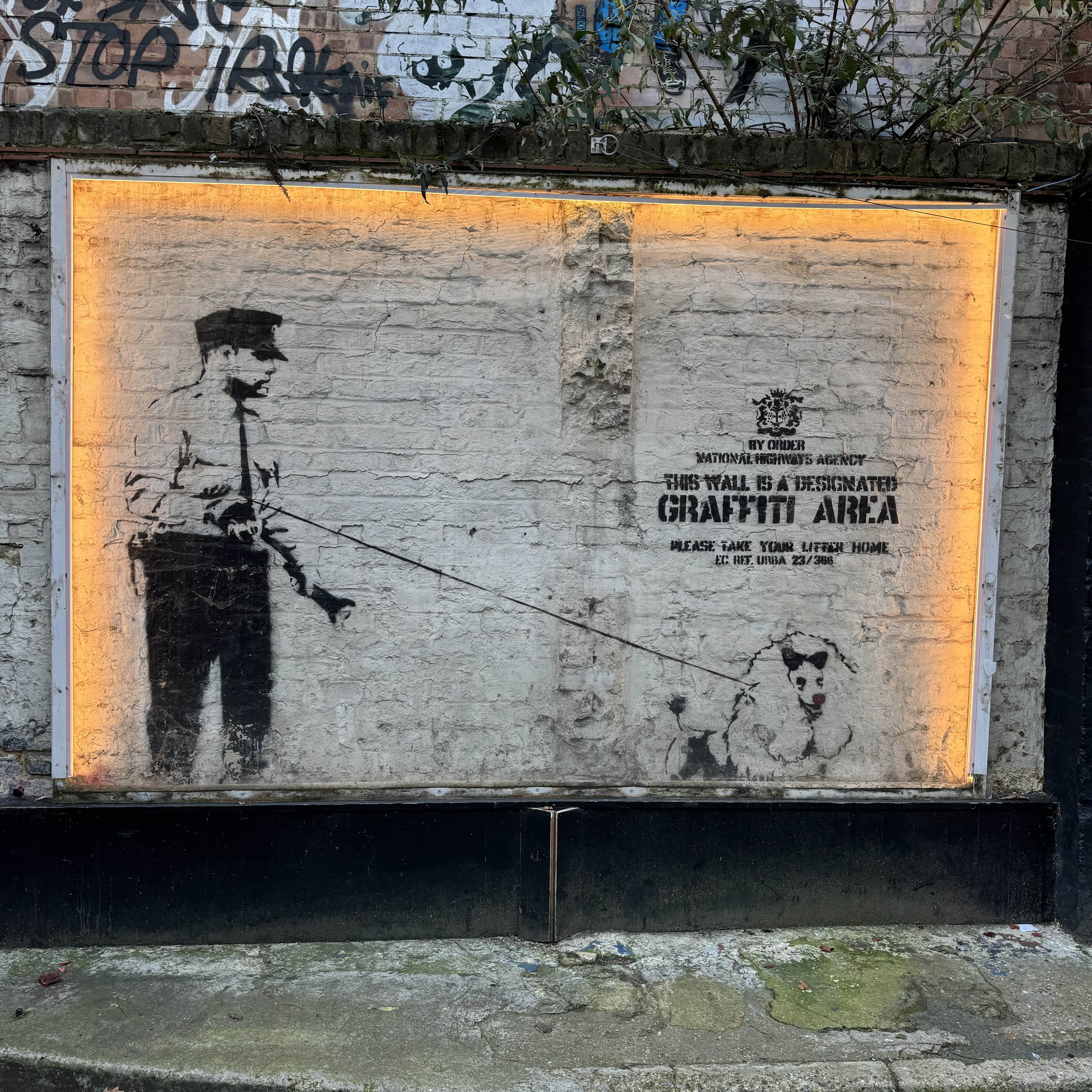 Street Art Tour London app on a smartphone displaying a digital map in front of artwork in Shoreditch, London.