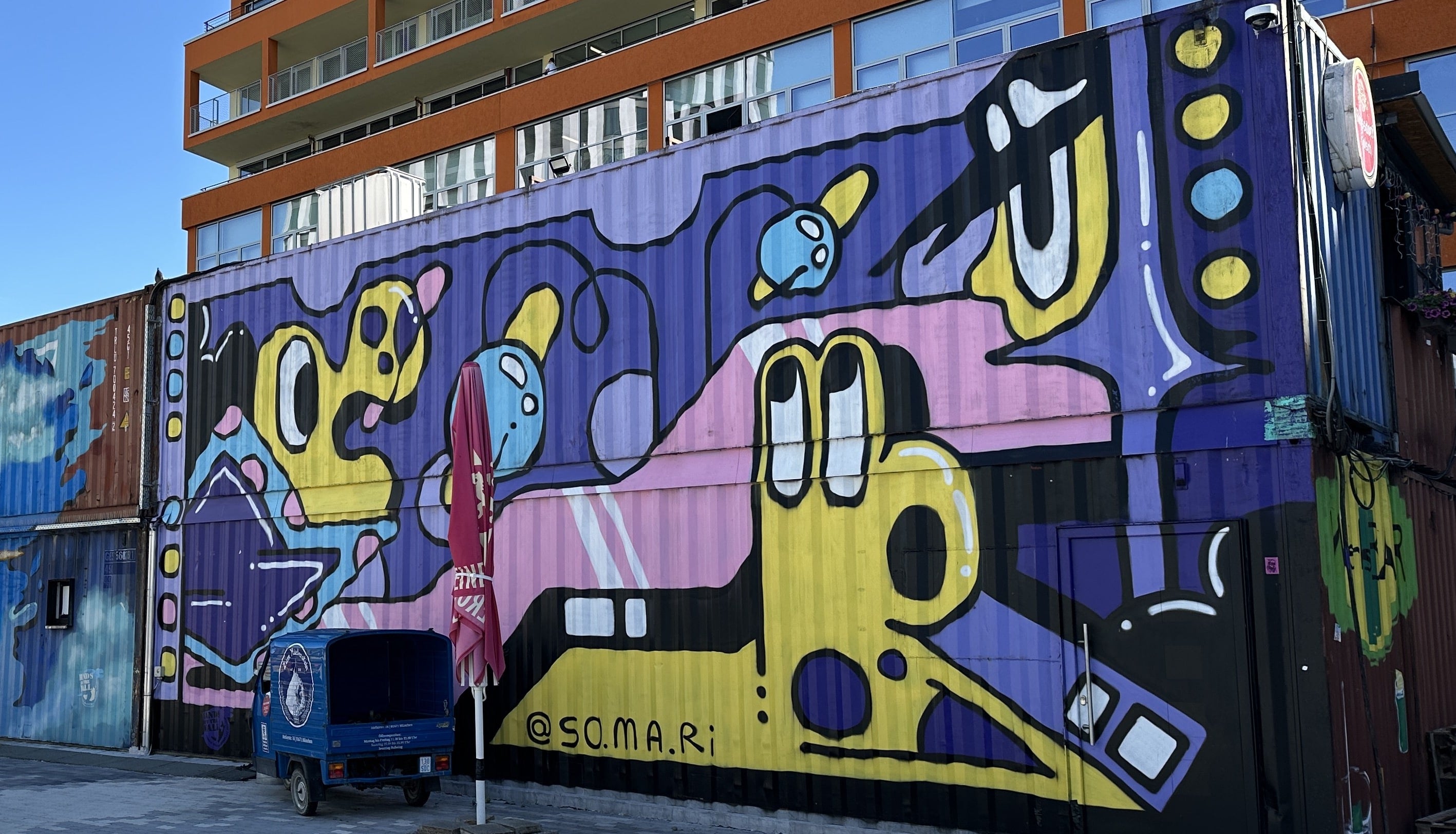 Street Art Tour Munich featuring the vibrant mural by Ptashka Somari, painted on a shipping container in the Werksviertel district of Munich.