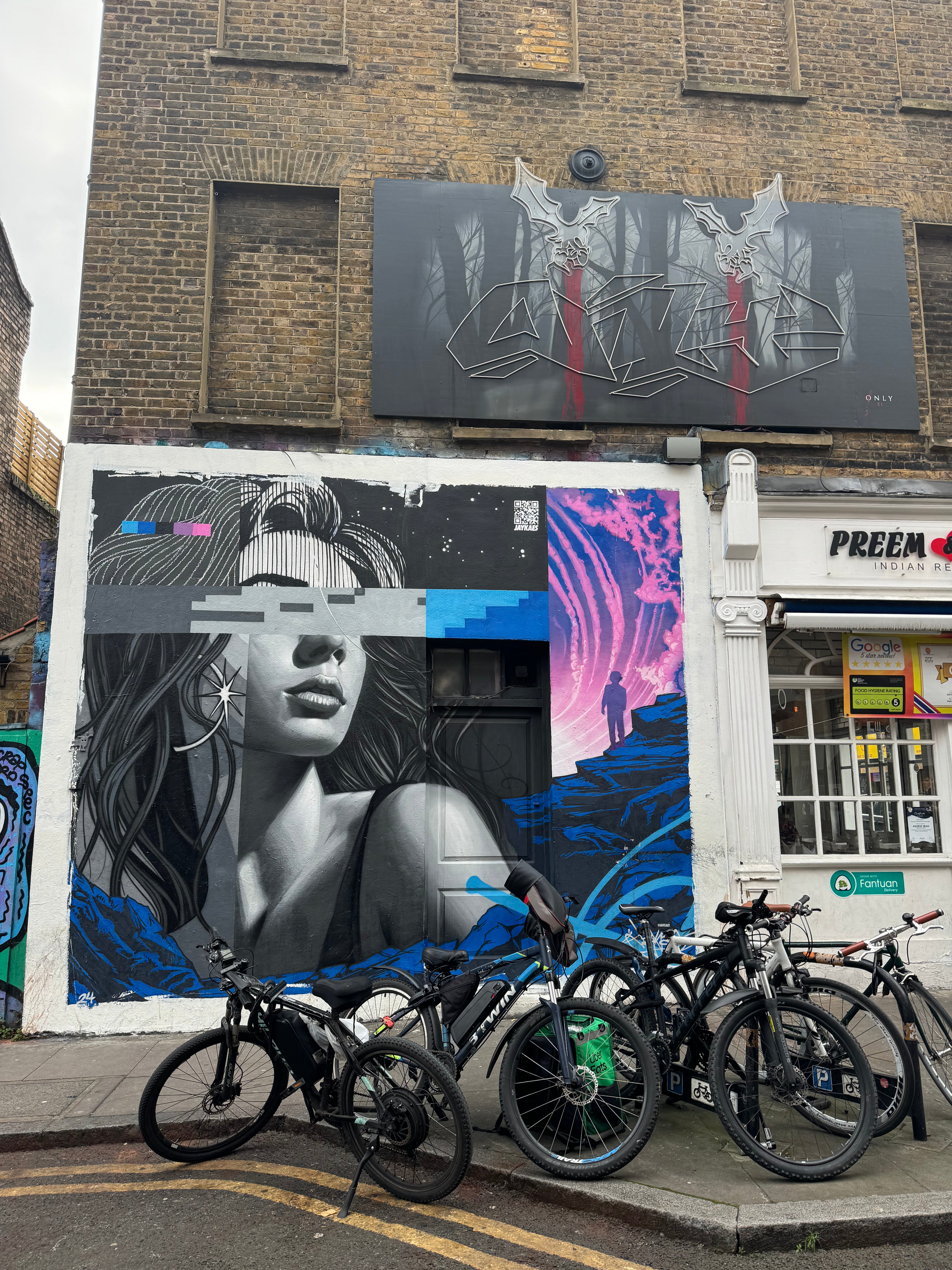 Team capturing colourful murals on Fashion Street on the London Team Building Street Art Walk.
