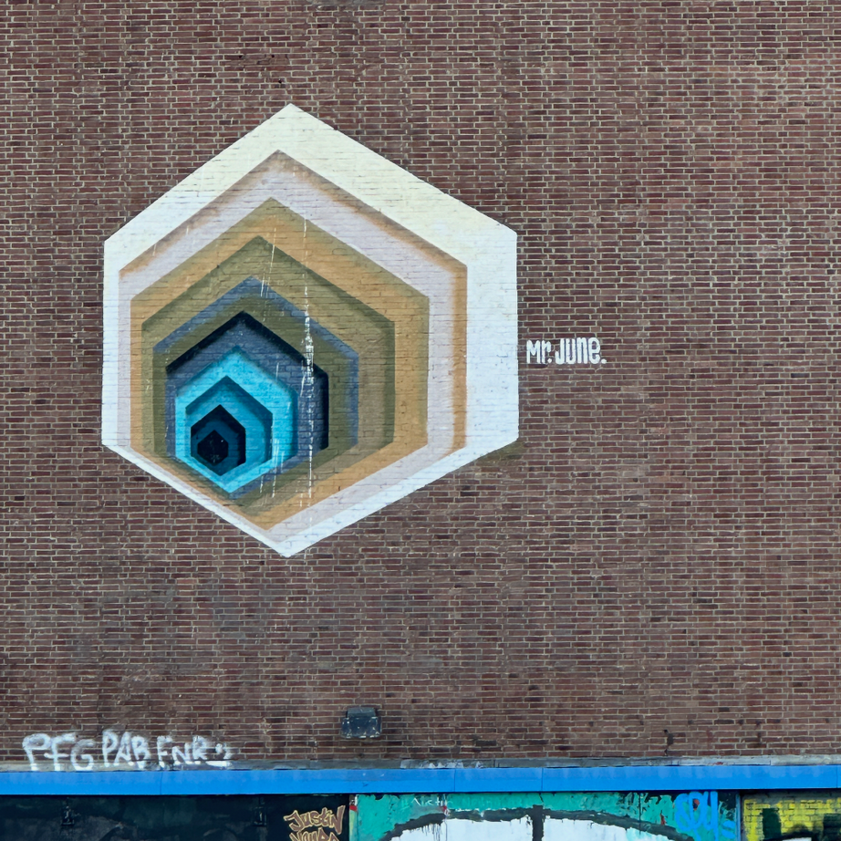 Group walking past geometric artworks by Mr. June on the Amsterdam Team Building Street Art Walk.