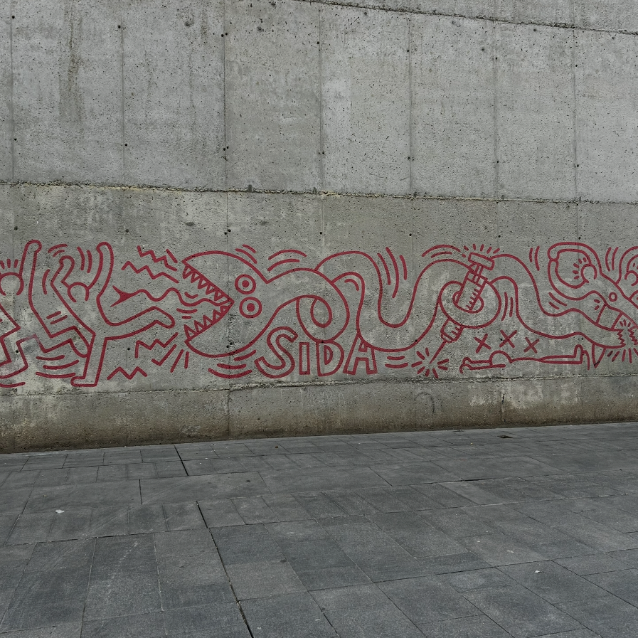 Corporate group discovering graffiti by Keith Haring and El Xupet Negre on the Barcelona Team Building Street Art Walk