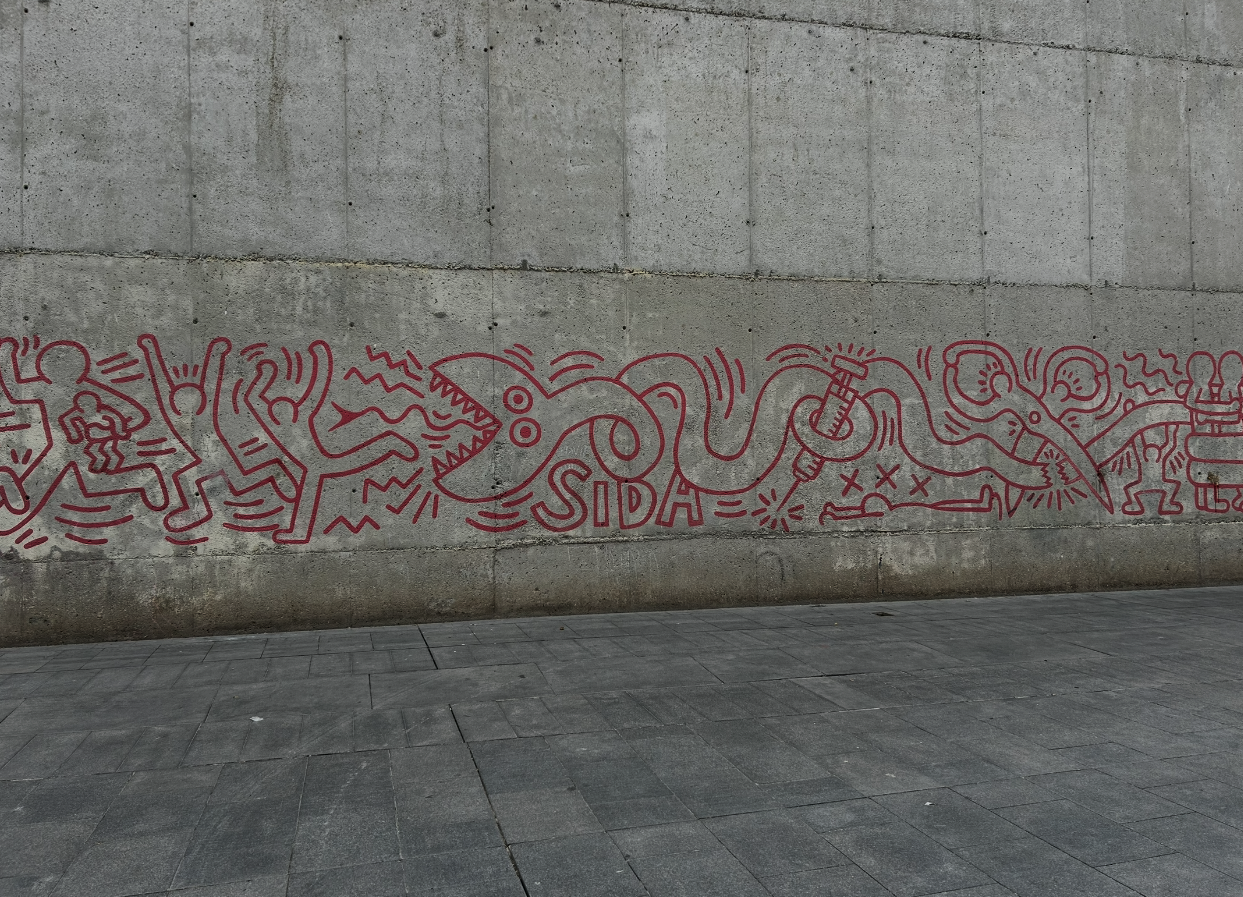 Corporate group discovering graffiti by Keith Haring and El Xupet Negre on the Barcelona Team Building Street Art Walk